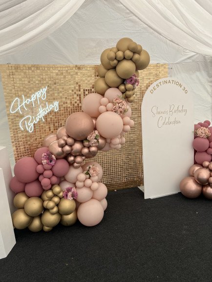 Gold sequin wall, balloon garland, sailboard with personalised vinyl transfer, florals and neon light