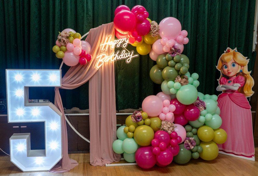 Balloon hoop with neon light and florals, character cut out, and 4ft LED number