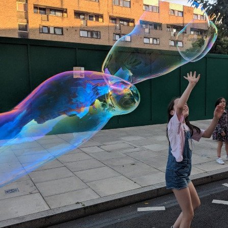 Children chasing giant bubbles