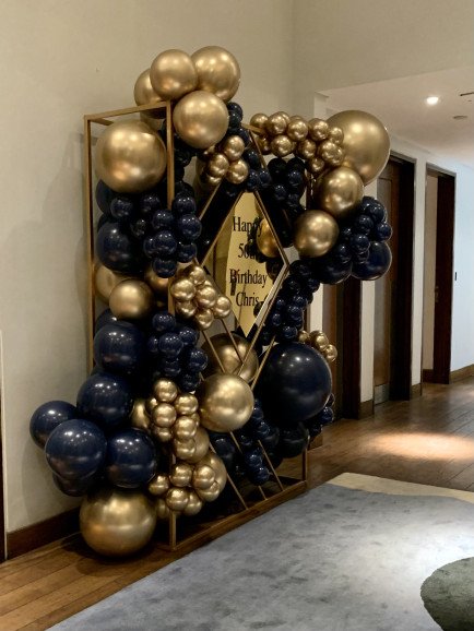 A stunning geometrical frame with stunning metallic balloons to welcome a 50th birthday dinner.