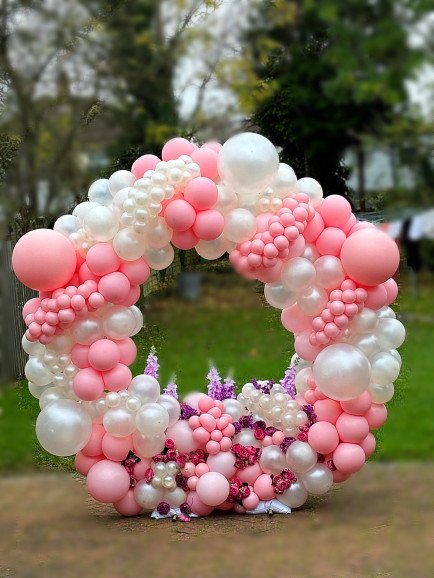 Create a romantic statement with this pink and pearl balloon hoop, adorned with delicate floral accents. Perfect for weddings, anniversaries, or elegant outdoor events, it’s a stunning backdrop for unforgettable moments.