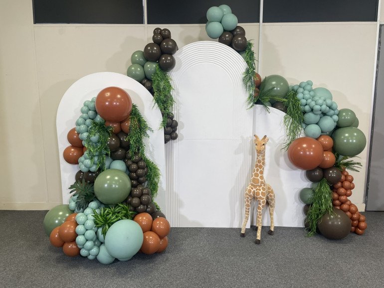 Bring the jungle to your event with this safari-themed balloon setup! Featuring earthy tones, lush greenery, and a playful giraffe prop, it’s perfect for kids’ birthdays, baby showers, or wild celebrations. Book this show-stopping backdrop today